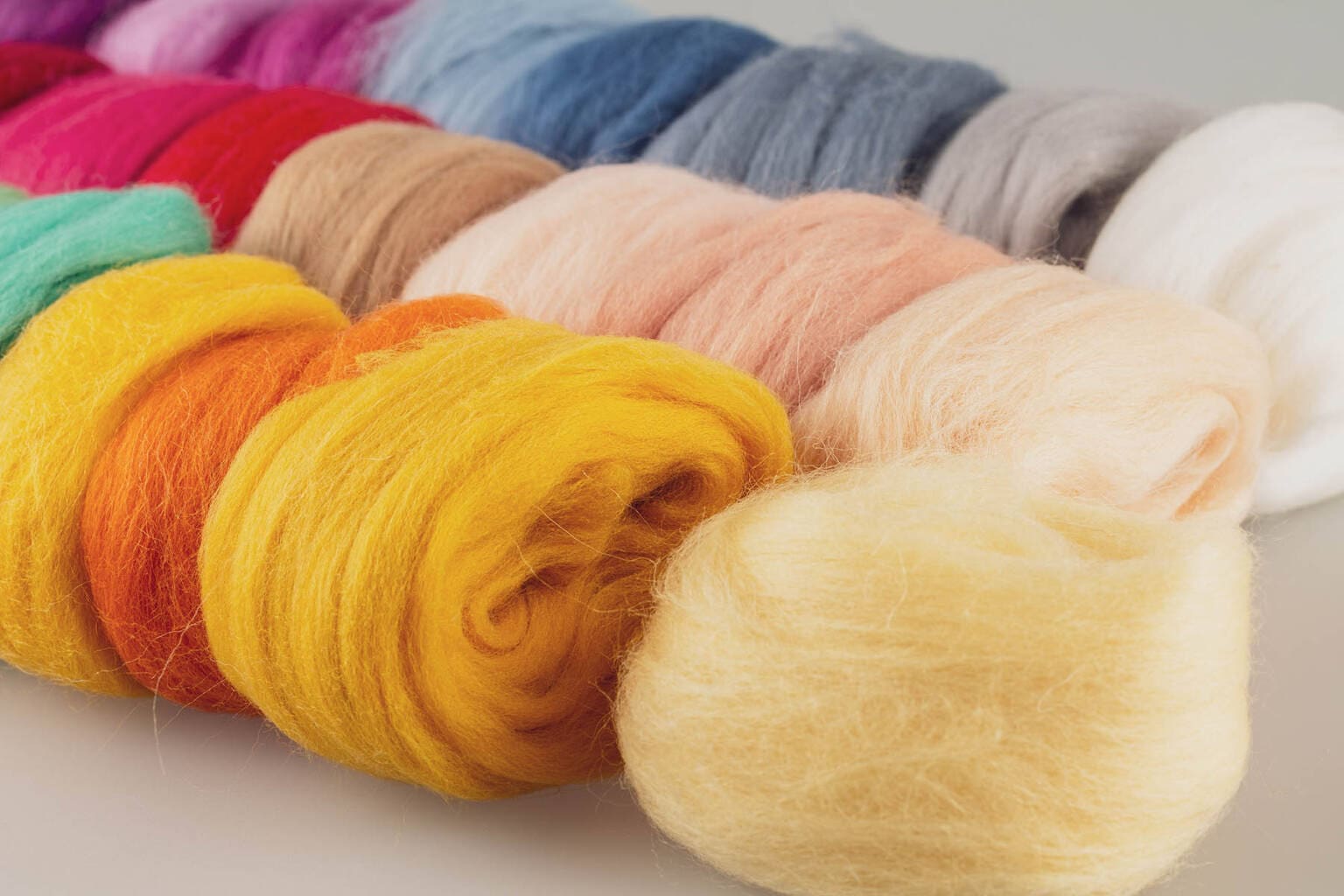 Wool fiber, merino wool of different colors bright colorful for yes handmade, knitting weaving and painting making, selective focus close up