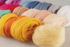 Wool fiber, merino wool of different colors bright colorful for yes handmade, knitting weaving and painting making, selective focus close up